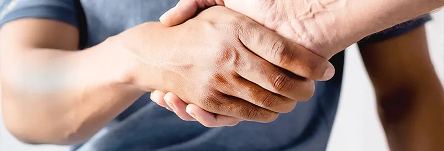 Dr Lincoln Tan shaking hands with a patient after a urology consultation in Singapore.